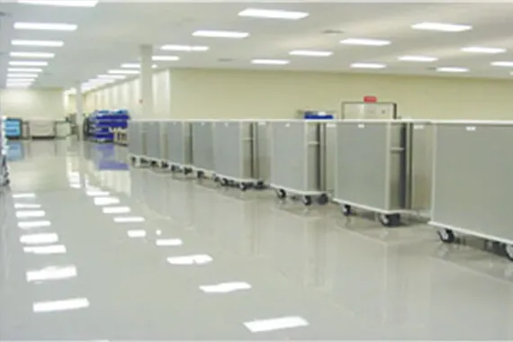 Rows of stainless steel instrument case carts in a clean sterile processing facility